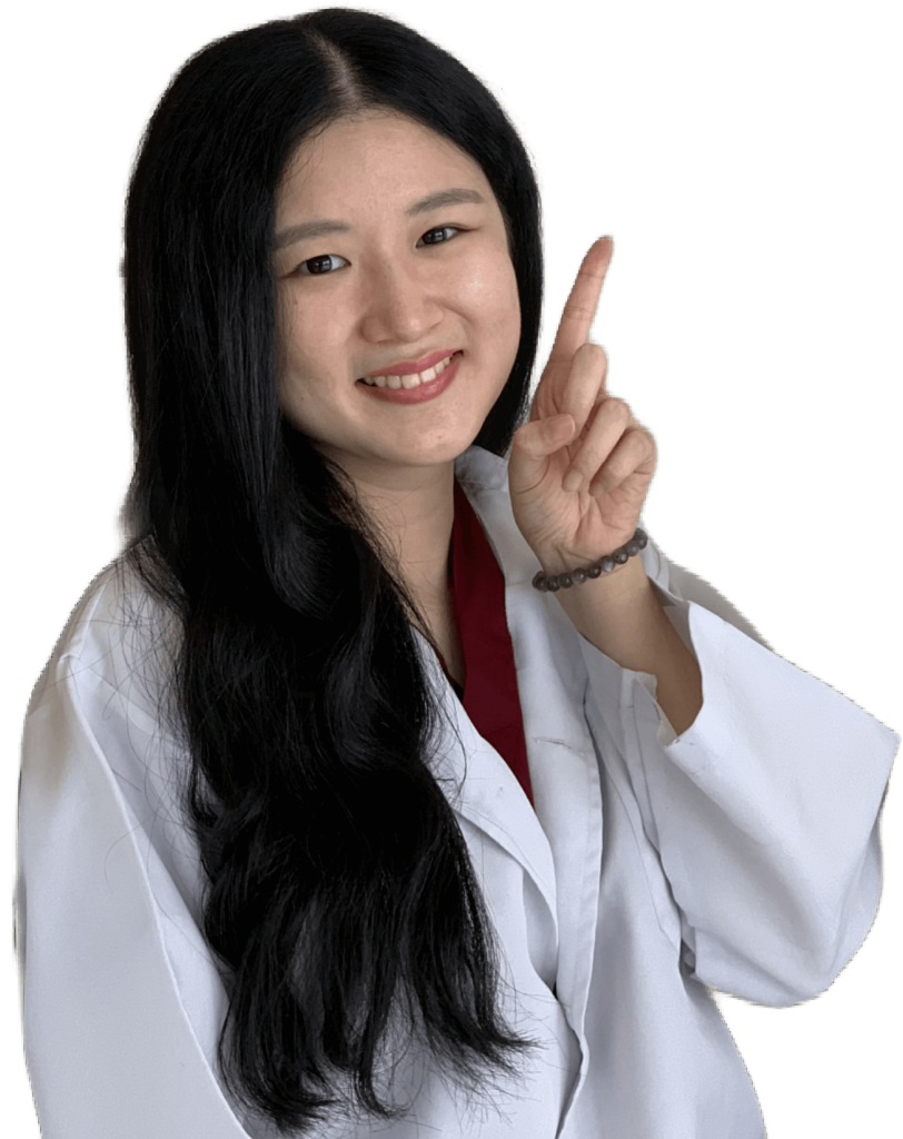 A lady dentist smiling with a lab coat pointing upwards