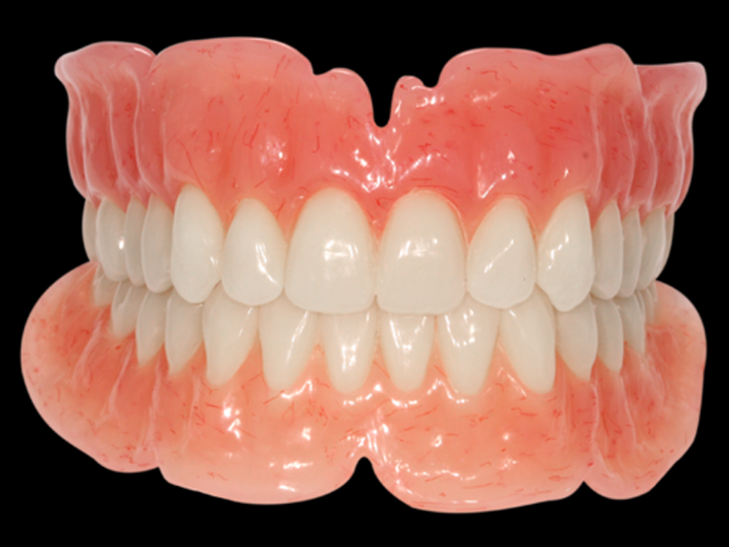 Complete upper and lower acrylic denture with teeth with black background